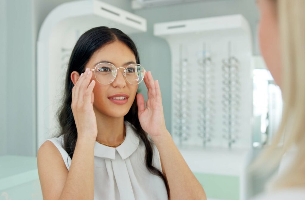 A person at their eye doctor’s office trying on a new pair of glasses, checking the fit and clarity to help with their myopia.