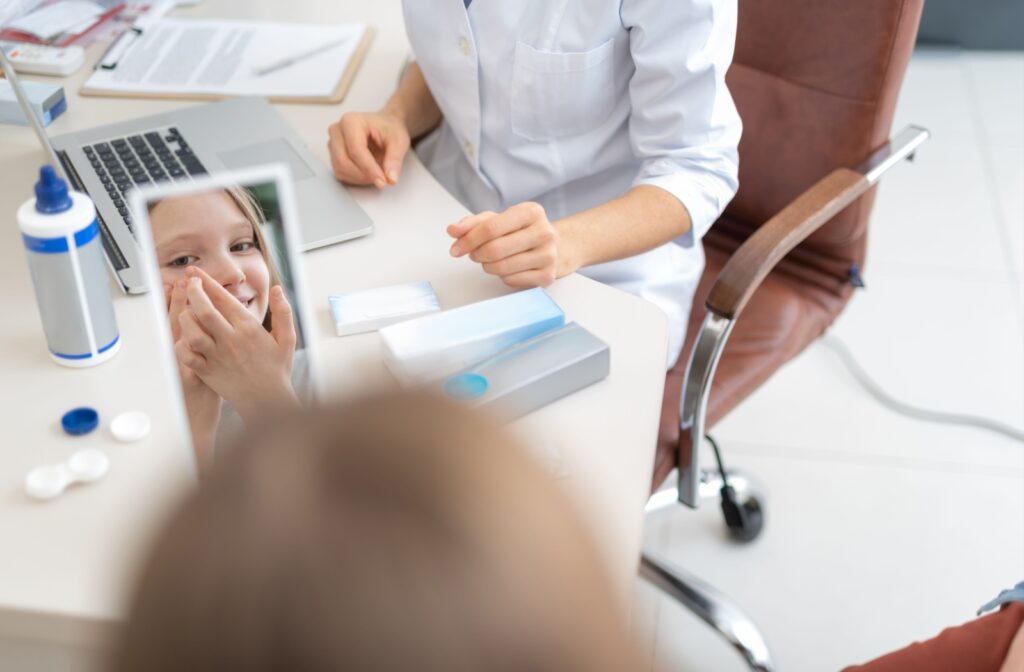 Optometrist guiding a child through contact lens use during an eye care appointment for myopia control