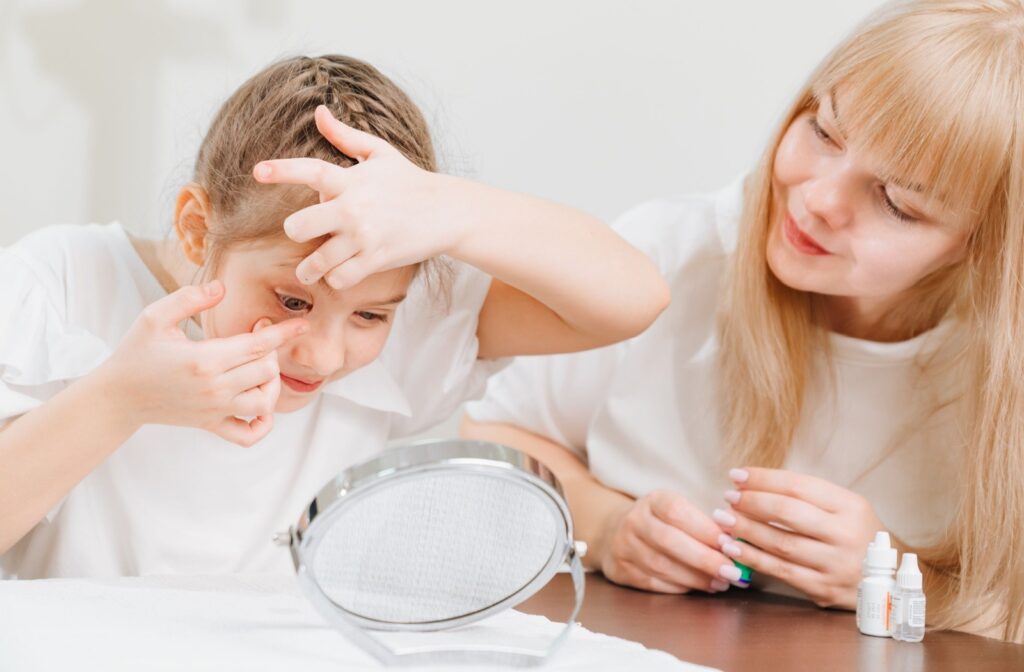 Child learning how to insert contact lenses with help from a parent, demonstrating myopia management in children